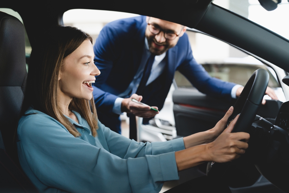 Woman inside a car smiling.