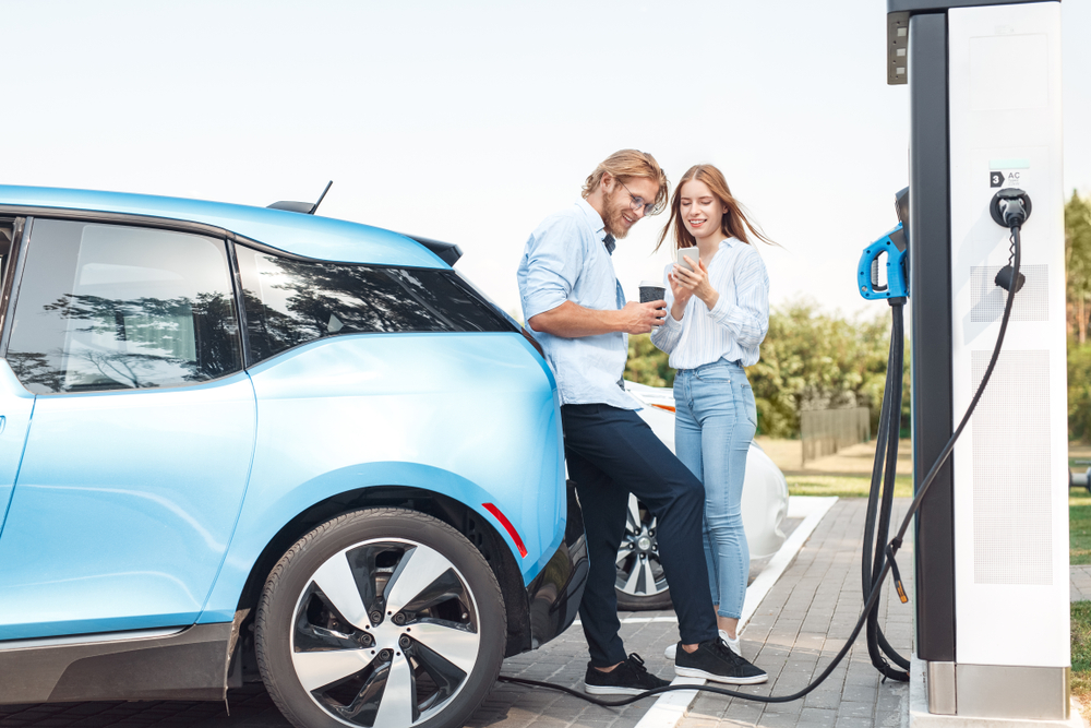 Couple traveling together with their electric car.