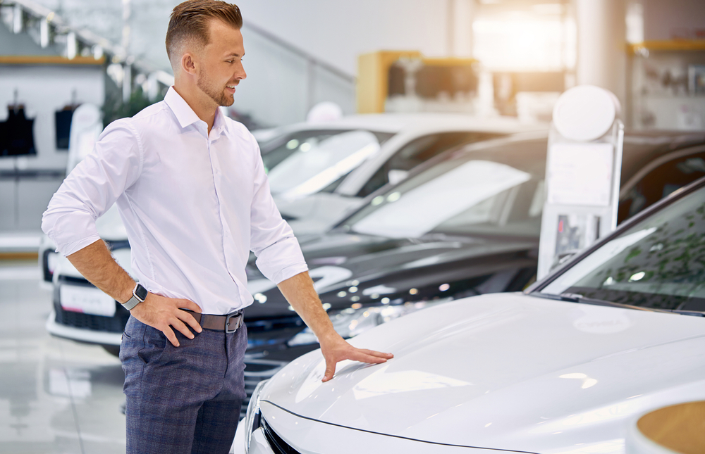 man touching a car.