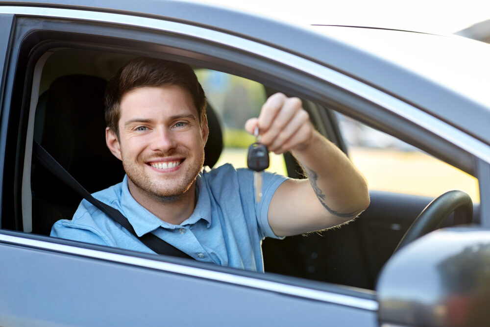 Man showing the key of his new car.