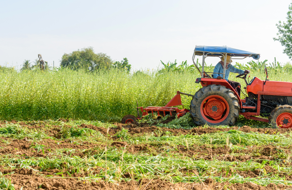 Farmer using tractor.