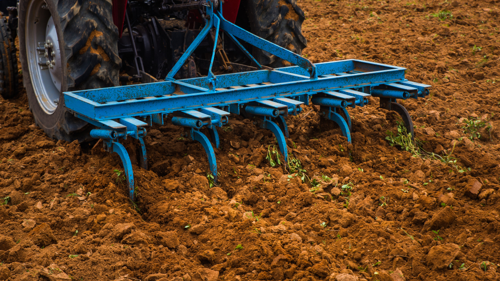 Farmer harrowing the agricultural field.